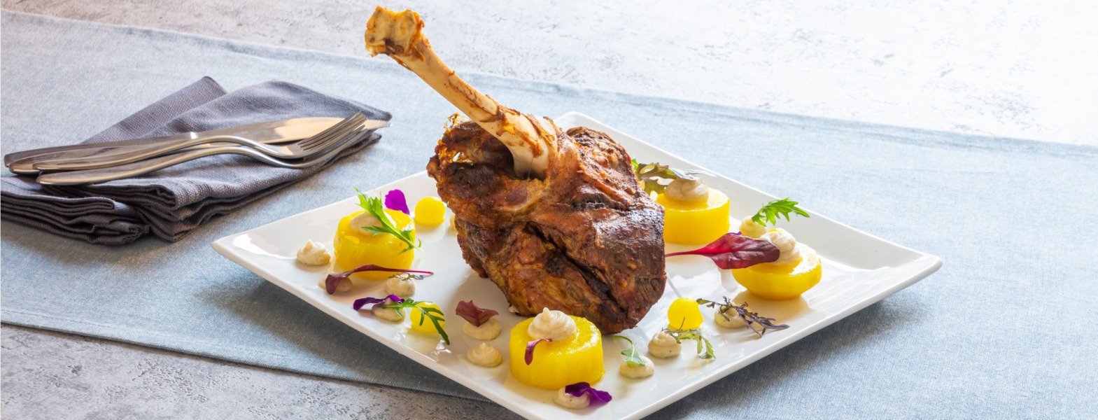 Stinco d'agnello al cartoccio, crema di sedano rapa e anelli di patate