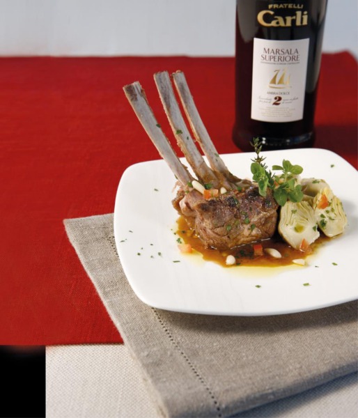 Su un piatto quadrato è servito il carrè di agnello con la sua salsa al Marsala e cuori di carciofo tagliati a metà