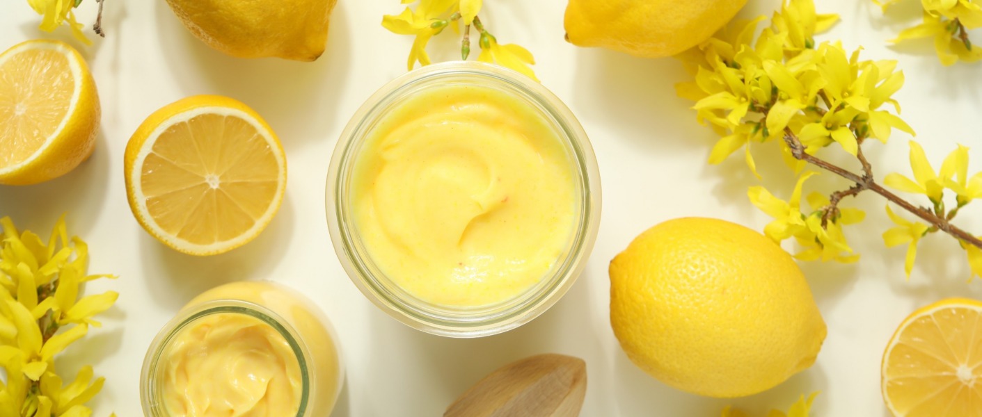 Crema gialla e vellutata servita su un elegante piatto bianco, decorata con scorzette di clementine