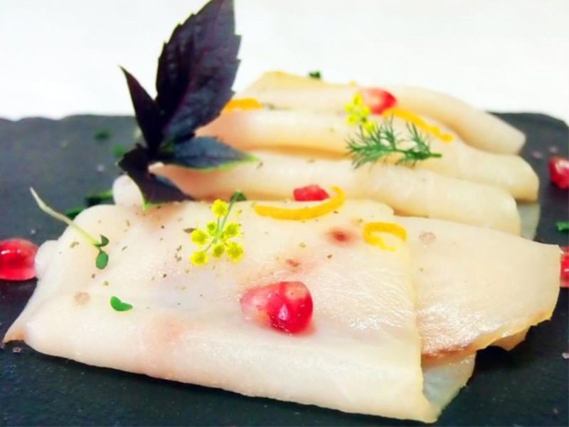 Carpaccio di spada affumicato, con melagrana e germogli di daikon