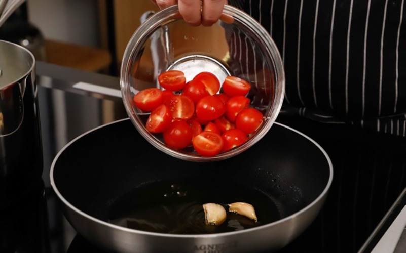 aggiungere i pomodori in una padella