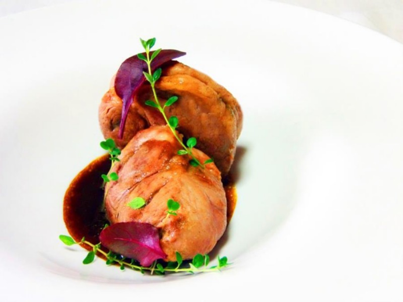 Filetto di maiale su piatto bianco su un sughetto di birra rossa e timo