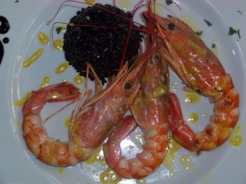 Gamberoni alla piastra con riso venere e gocce di salsa al curry