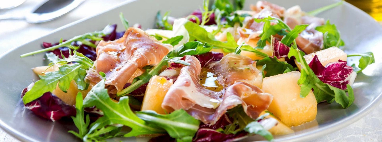 Un piatto di insalata fresco e colorato con prodotti tipici della cucina Valtellina, dal formaggio alla bresaola