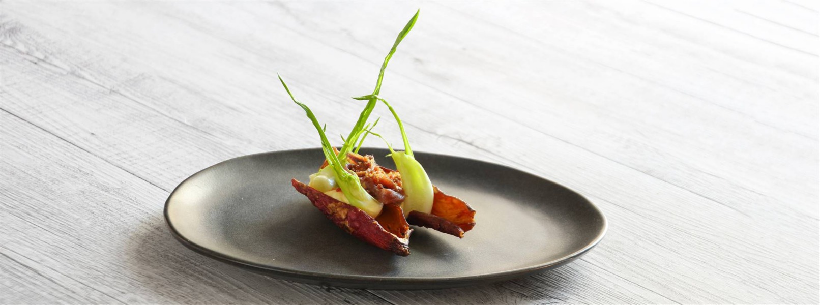 Patata al cartoccio con puntarelle, alici e speck