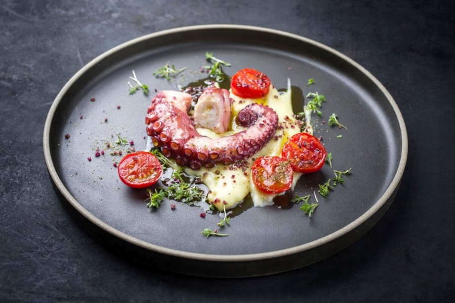 Polpo con crema di patate al cartoccio, pomodori arrostiti e pepe rosa 