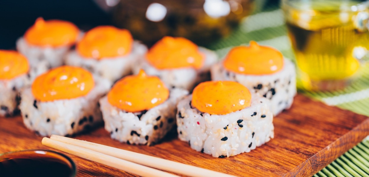 Il sushi uramaki decorato con le uova di pesce volante è adagiato in un piatto bianco