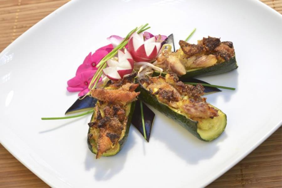 Le zucchine sono tagliate a barchette cilindriche per contenere il ripieno di sgombro e decorate con pangrattato