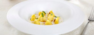 Tortellini di Modena su fonduta di Parmigiano Reggiano con cipolla croccantealt