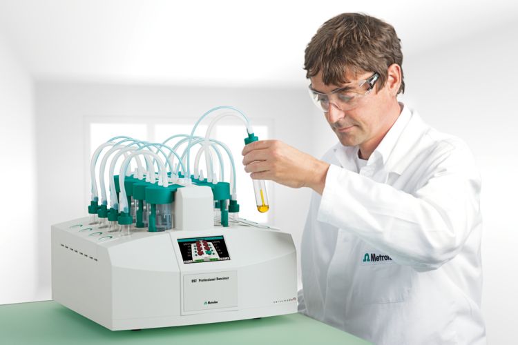 Preparing a measurement in position B4 with the 892 Professional Rancimat. Male lab worker holding an 61429040 Reaction vessel containing an oil sample. Contains picture 3580