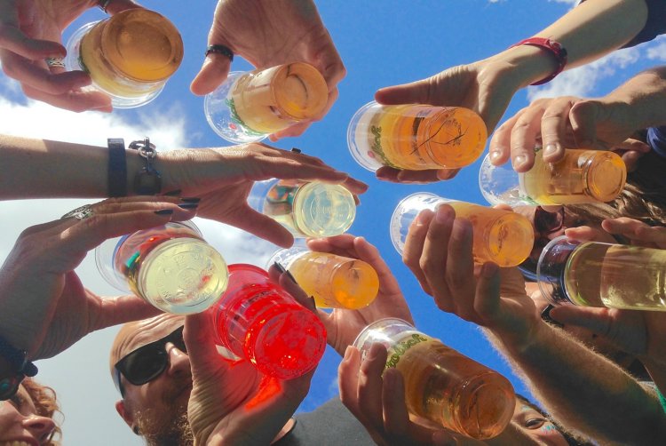 Diversas pessoas brindando com copos de cerveja.