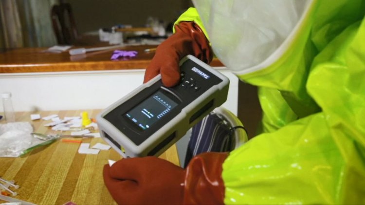 Profissional com vestimenta especial realizando análises com o equipamento Raman