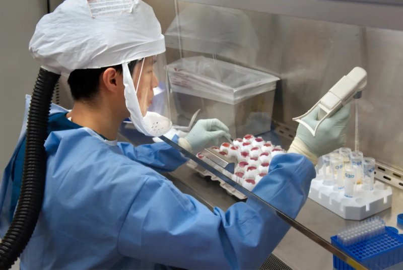 virus detection, female lab technician in laboratory with visur samples in front of her
