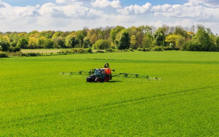 Trator em campo pulverizando herbicidas, glifosato e AMPA