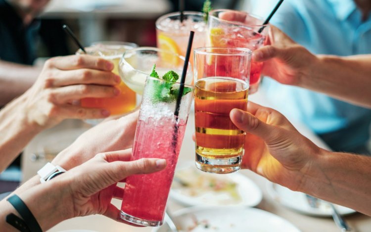 Hands holding vrious cocktails and glasses