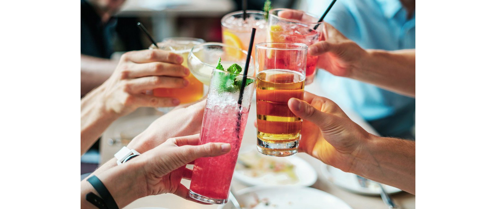 Hands holding vrious cocktails and glasses